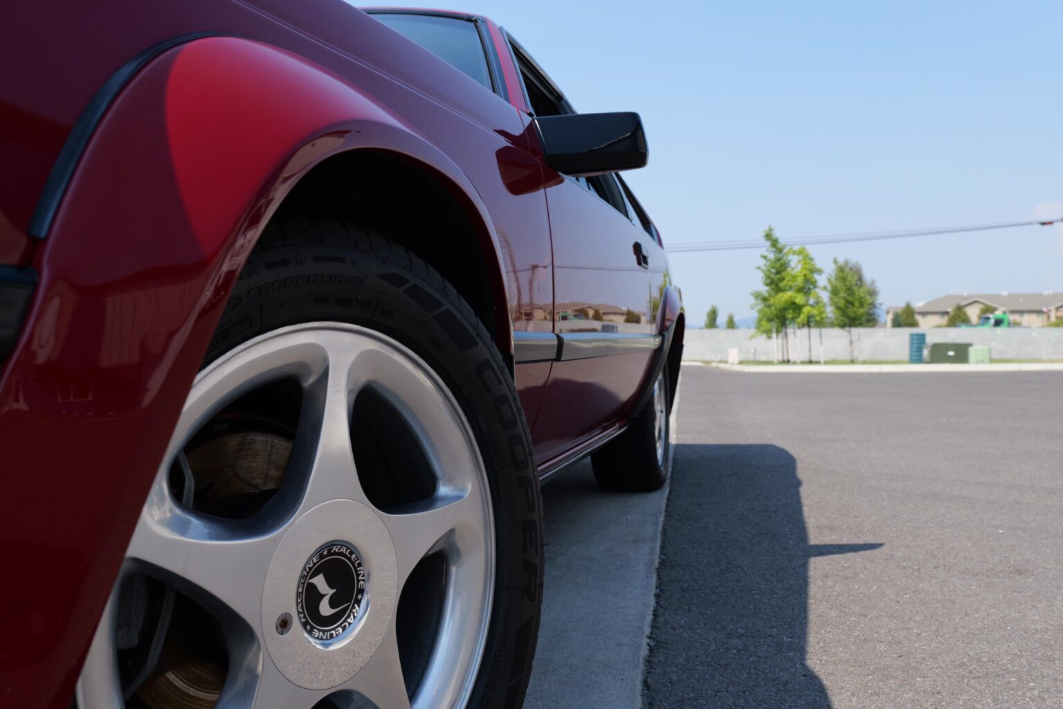 Red car exterior showcasing clean paint and wheel after professional automotive detailing and ceramic coating application